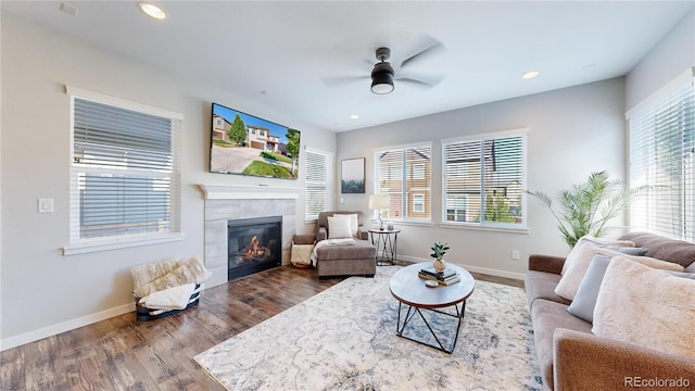 living room with ceiling fan, a tile fireplace, and dark hardwood / wood-style flooring