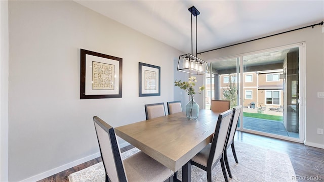 dining area with dark hardwood / wood-style flooring and an inviting chandelier