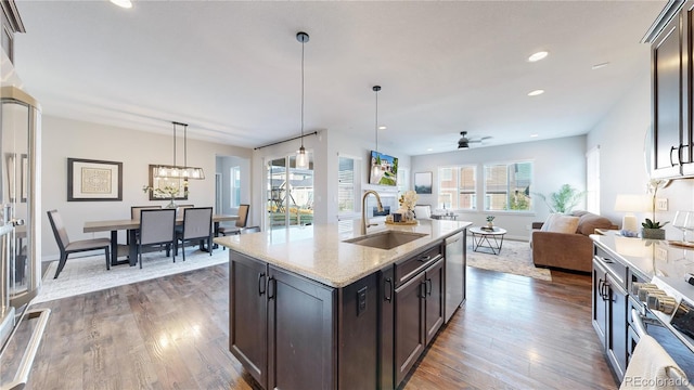 kitchen with ceiling fan, light stone countertops, dark hardwood / wood-style flooring, and sink