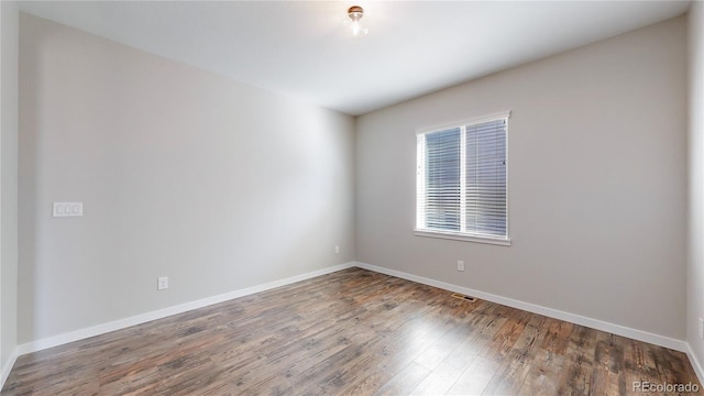 unfurnished room with dark wood-type flooring