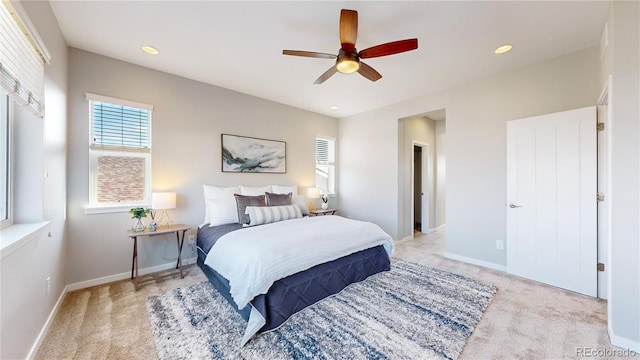 bedroom featuring light colored carpet and ceiling fan