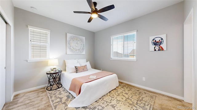 carpeted bedroom featuring ceiling fan and a closet