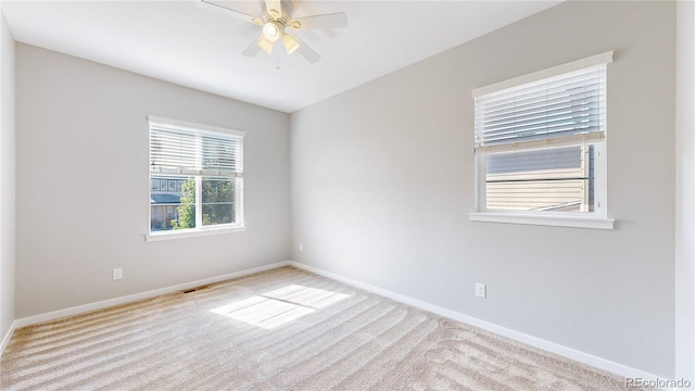 spare room featuring light colored carpet and ceiling fan