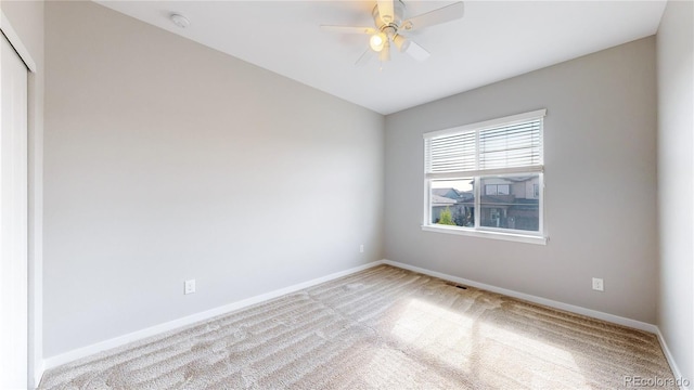 carpeted spare room with ceiling fan