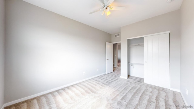 unfurnished bedroom featuring a closet, ceiling fan, and light colored carpet