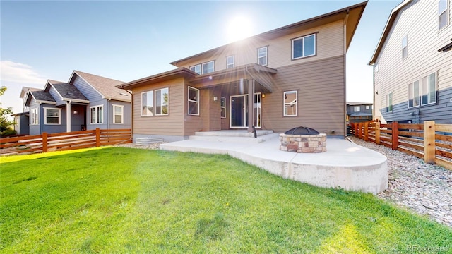 rear view of house with a yard and an outdoor fire pit