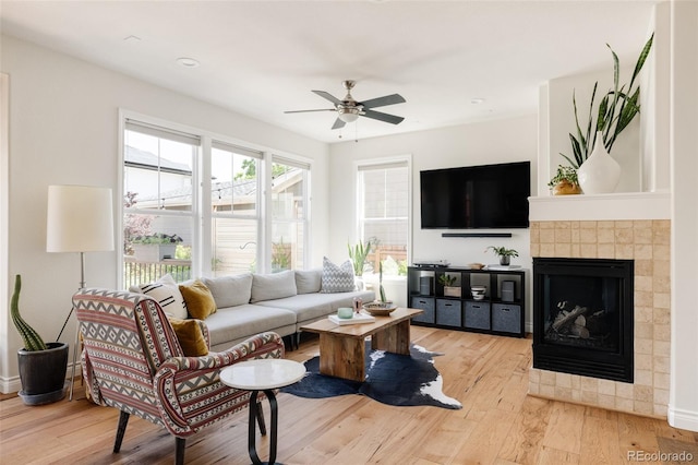 10069 E 28th Ave, Denver, CO 80238 - living area featuring light wood-style floors, a ceiling fan, and a tile fireplace