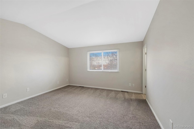 unfurnished room featuring carpet floors, baseboards, and vaulted ceiling