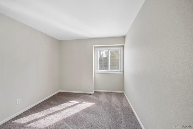 empty room with baseboards and light colored carpet