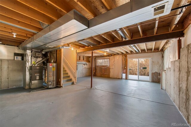 below grade area with water heater, stairway, visible vents, and heating unit