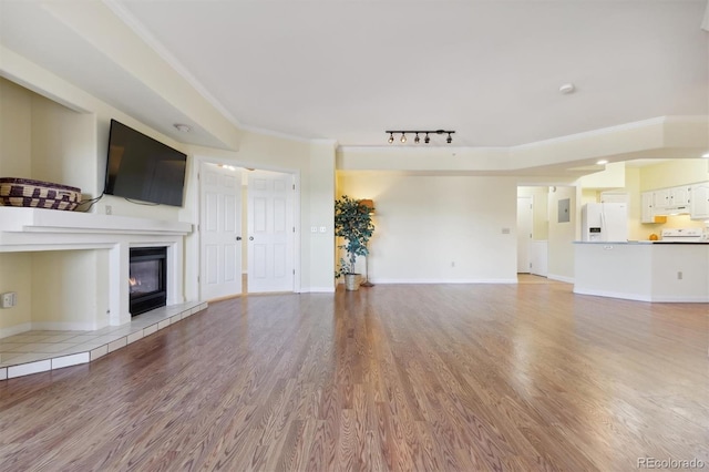 unfurnished living room featuring a fireplace, hardwood / wood-style flooring, and ornamental molding