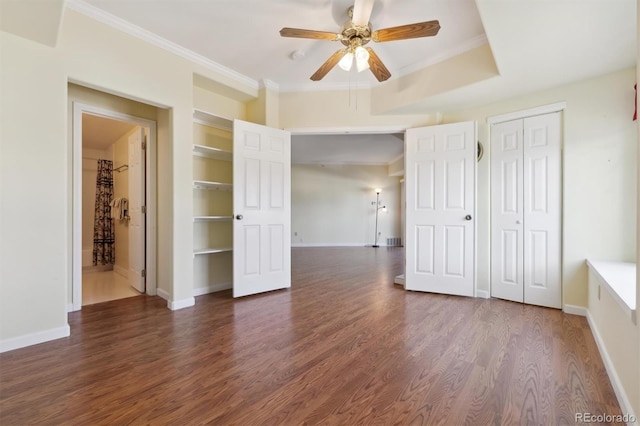 unfurnished bedroom featuring dark hardwood / wood-style flooring, ensuite bath, ceiling fan, and crown molding