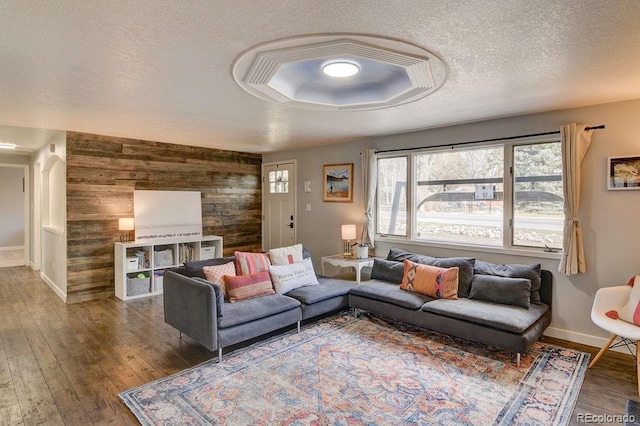 811 W Main St, Buena Vista, CO 81211 - living area featuring a textured ceiling, baseboards, wooden walls, an accent wall, and wood finished floors