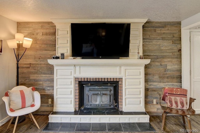 811 W Main St, Buena Vista, CO 81211 - room details featuring a wood stove, a textured ceiling, wooden walls, and wood finished floors
