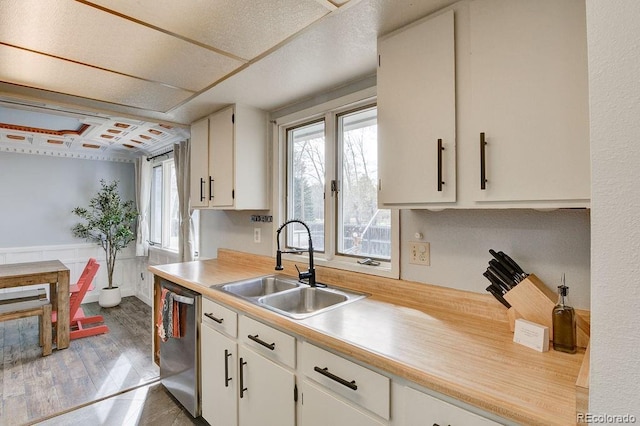811 W Main St, Buena Vista, CO 81211 - kitchen featuring stainless steel dishwasher, a sink, white cabinetry, wood finished floors, and light countertops