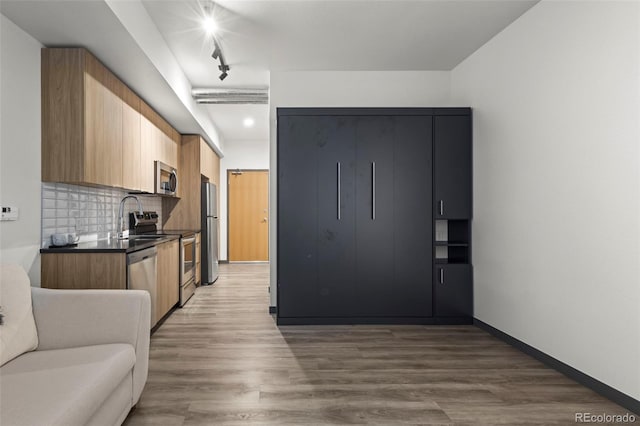 kitchen featuring decorative backsplash, hardwood / wood-style floors, and stainless steel appliances