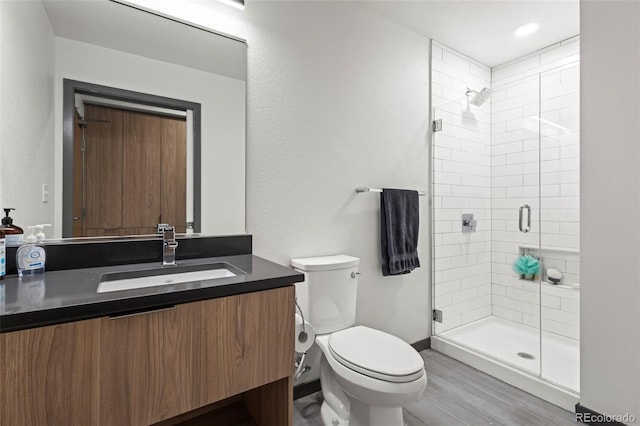 bathroom with vanity, toilet, wood-type flooring, and walk in shower