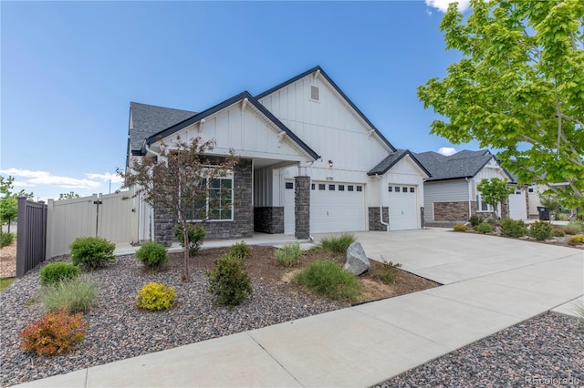 21701 E 50th Dr, Aurora, CO 80019 - view of front of house with board and batten siding, a porch, a garage, stone siding, and concrete driveway