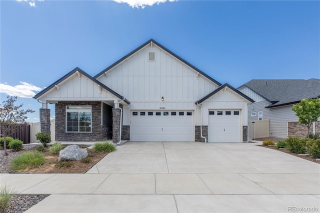 21701 E 50th Dr, Aurora, CO 80019 - view of front of home featuring board and batten siding, stone siding, a garage, and concrete driveway