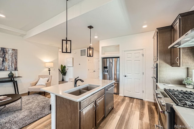 21701 E 50th Dr, Aurora, CO 80019 - kitchen featuring stainless steel appliances, a sink, dark brown cabinetry, light wood-type flooring, and recessed lighting
