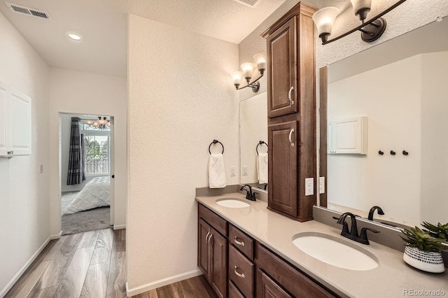 21701 E 50th Dr, Aurora, CO 80019 - ensuite bathroom featuring wood finished floors, double vanity, baseboards, and recessed lighting
