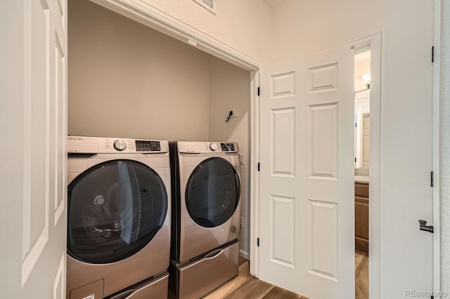 21701 E 50th Dr, Aurora, CO 80019 - laundry room featuring washer and dryer and wood finished floors