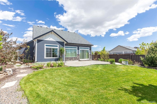 21701 E 50th Dr, Aurora, CO 80019 - back of house with a patio area, board and batten siding, roof with shingles, and stone siding