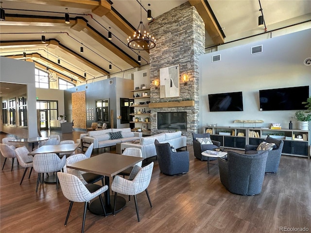 21701 E 50th Dr, Aurora, CO 80019 - dining space with high vaulted ceiling, wood finished floors, beamed ceiling, a stone fireplace, and a chandelier