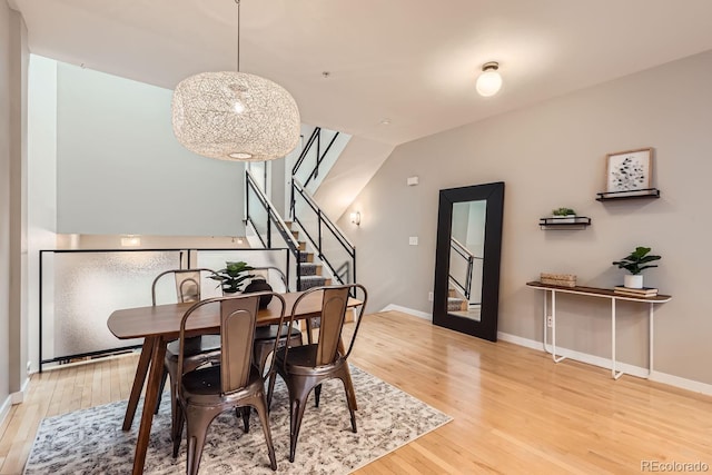 dining area featuring stairs, baseboards, and wood finished floors