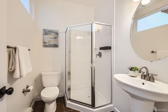 full bath with a stall shower, baseboards, a sink, and toilet