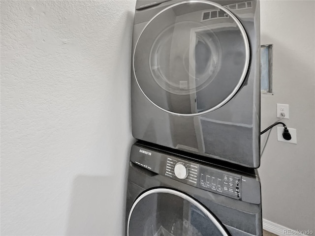 laundry area with stacked washing maching and dryer