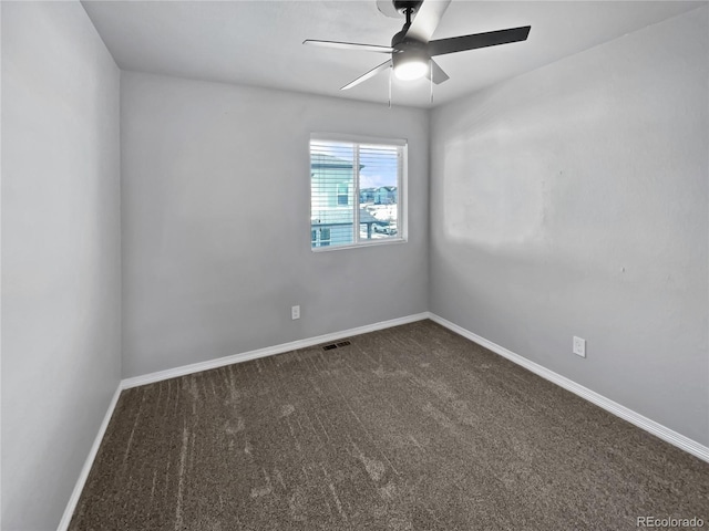 empty room with ceiling fan and dark colored carpet