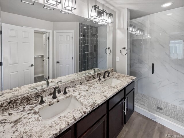 bathroom featuring a shower with door, vanity, and hardwood / wood-style floors