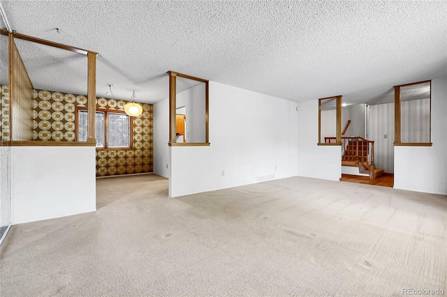 11936 E Oregon Cir, Aurora, CO 80012 - unfurnished living room featuring stairs, carpet, and a textured ceiling