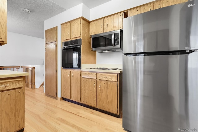 11936 E Oregon Cir, Aurora, CO 80012 - kitchen featuring appliances with stainless steel finishes, light wood finished floors, light countertops, and a textured ceiling