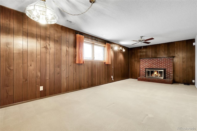 11936 E Oregon Cir, Aurora, CO 80012 - unfurnished living room featuring a ceiling fan, wood walls, a textured ceiling, and a fireplace