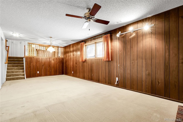 11936 E Oregon Cir, Aurora, CO 80012 - empty room featuring stairway, wood walls, carpet floors, a textured ceiling, and ceiling fan