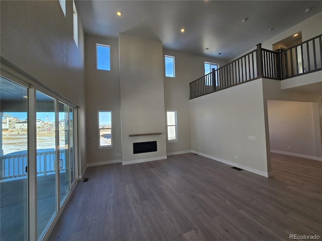 unfurnished living room featuring a towering ceiling and a wealth of natural light