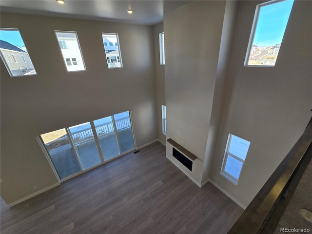 unfurnished living room featuring dark wood-type flooring and a healthy amount of sunlight