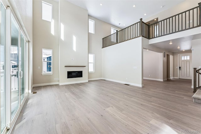 unfurnished living room featuring a healthy amount of sunlight and light hardwood / wood-style flooring