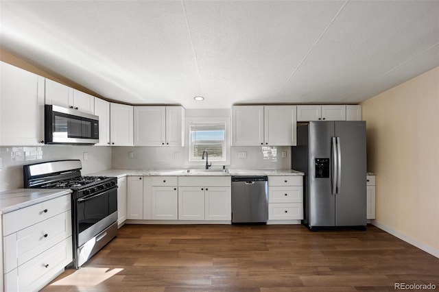 63560 Huckleberry Rd, Fowler, CO 81039 - kitchen with appliances with stainless steel finishes, a sink, backsplash, dark wood-type flooring, and recessed lighting