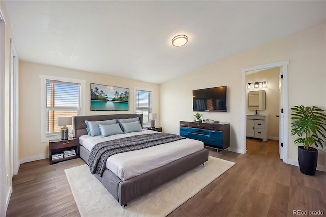 63560 Huckleberry Rd, Fowler, CO 81039 - bedroom featuring wood finished floors, baseboards, vaulted ceiling, and ensuite bathroom