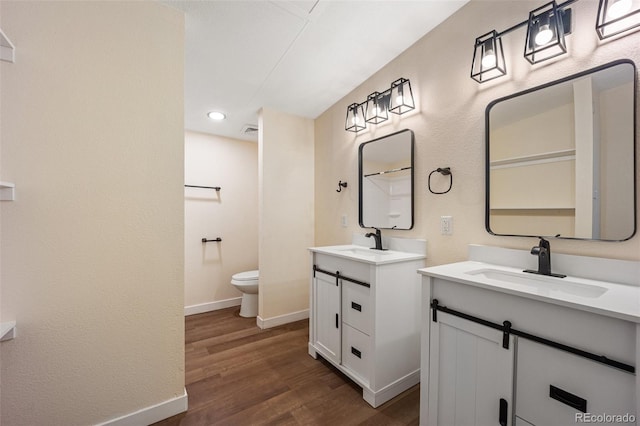 63560 Huckleberry Rd, Fowler, CO 81039 - full bath with two vanities, wood finished floors, toilet, baseboards, and recessed lighting