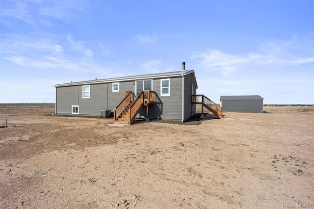 63560 Huckleberry Rd, Fowler, CO 81039 - rear view of house featuring central AC, stairs, and an outdoor structure