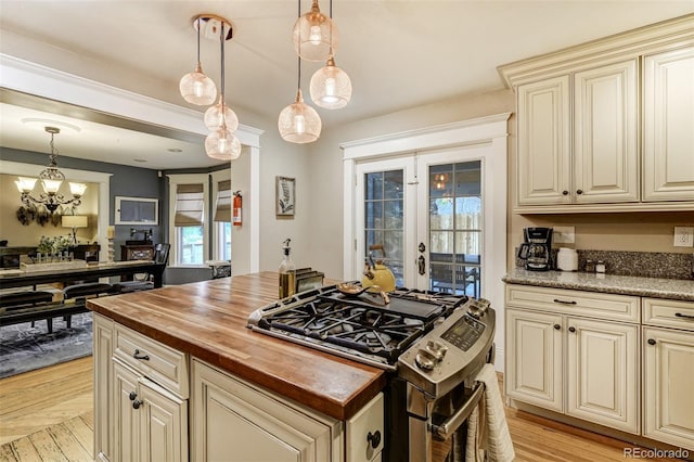 1510 S Cascade Ave, Colorado Springs, CO 80905 - kitchen with cream cabinetry, stainless steel gas stove, butcher block countertops, french doors, and a chandelier