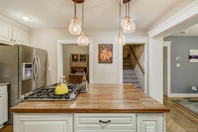 1510 S Cascade Ave, Colorado Springs, CO 80905 - kitchen with butcher block counters, stainless steel fridge, wood finished floors, a kitchen island, and white cabinetry