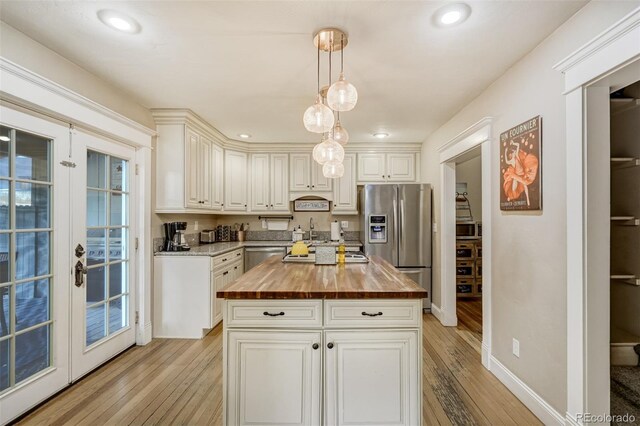 1510 S Cascade Ave, Colorado Springs, CO 80905 - kitchen with wooden counters, stainless steel appliances, light wood-style flooring, hanging light fixtures, and a center island