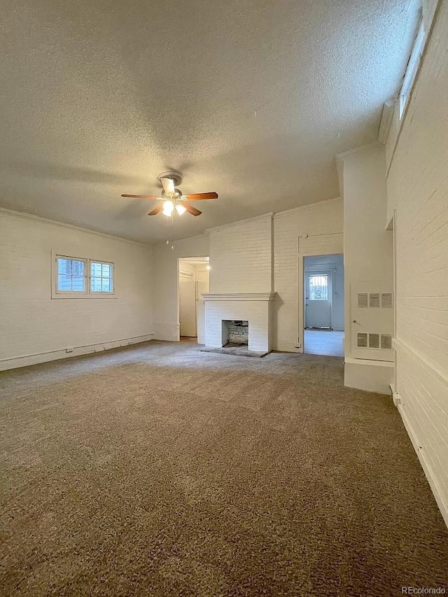 unfurnished living room featuring ceiling fan, a fireplace, carpet floors, and a textured ceiling