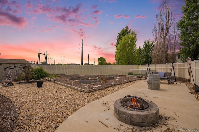 9650 Raven St, Firestone, CO 80504 - fenced backyard featuring a fire pit, a vegetable garden, and a patio