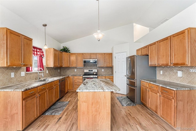 9650 Raven St, Firestone, CO 80504 - kitchen with stainless steel appliances, a sink, lofted ceiling, light wood-style floors, and a center island